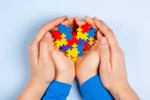 Manos con un puzzle en forma de corazón.